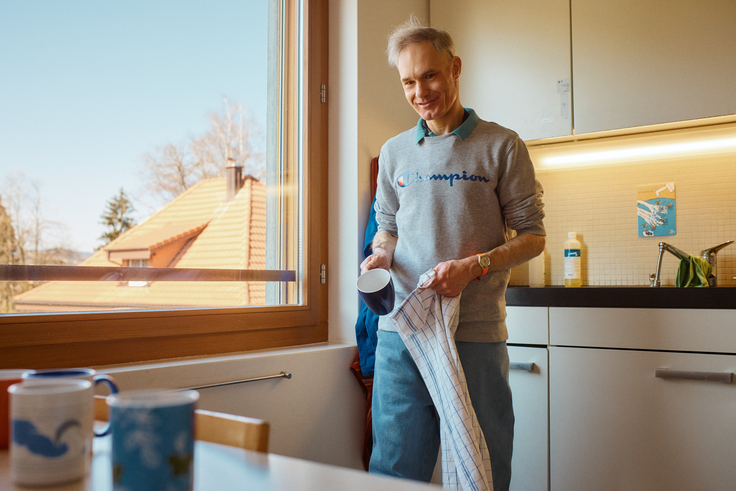 Ein Mann trocknet Geschirr ab.