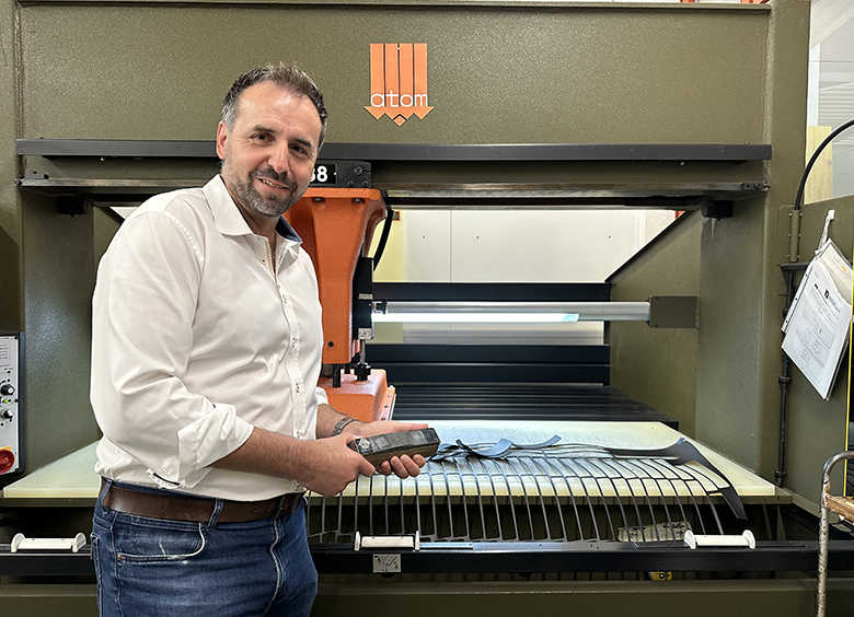 Alfred Doerfliger ist der Bereichleiter Arbeit und steht vor einer Maschine.