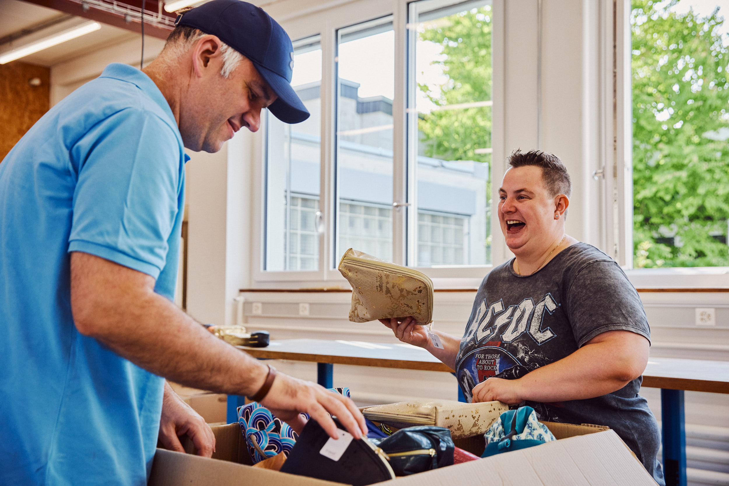 Geschützte Arbeitsplätze in der Montagen und Verpackungen: Mitarbeitende beim Verpacken von Taschen.